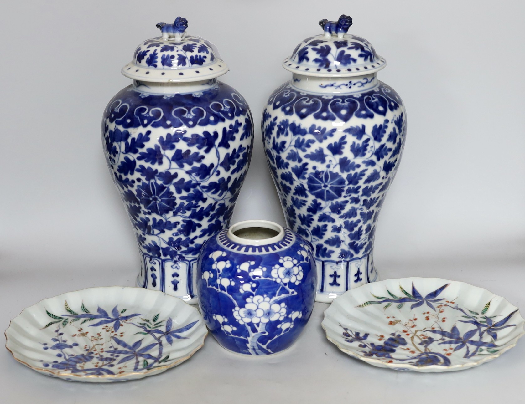 Two early 20th century Chinese blue and white vases with lion dog covers, together with a blue and white prunus jar and a pair of Japanese export flower dishes, and covers 33cm high